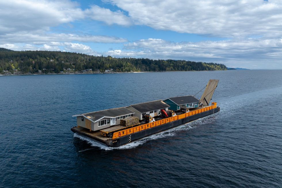 A barge transporting the homes to their new destination.