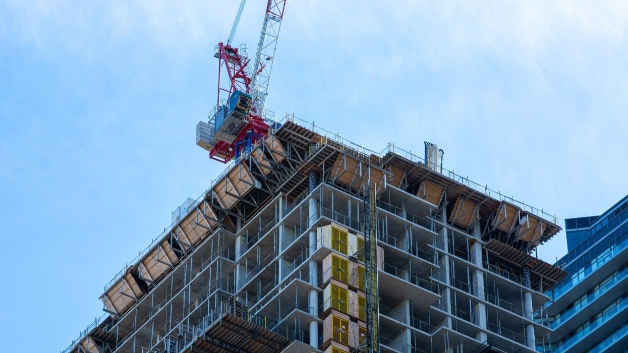 A building under construction with a crane on top.