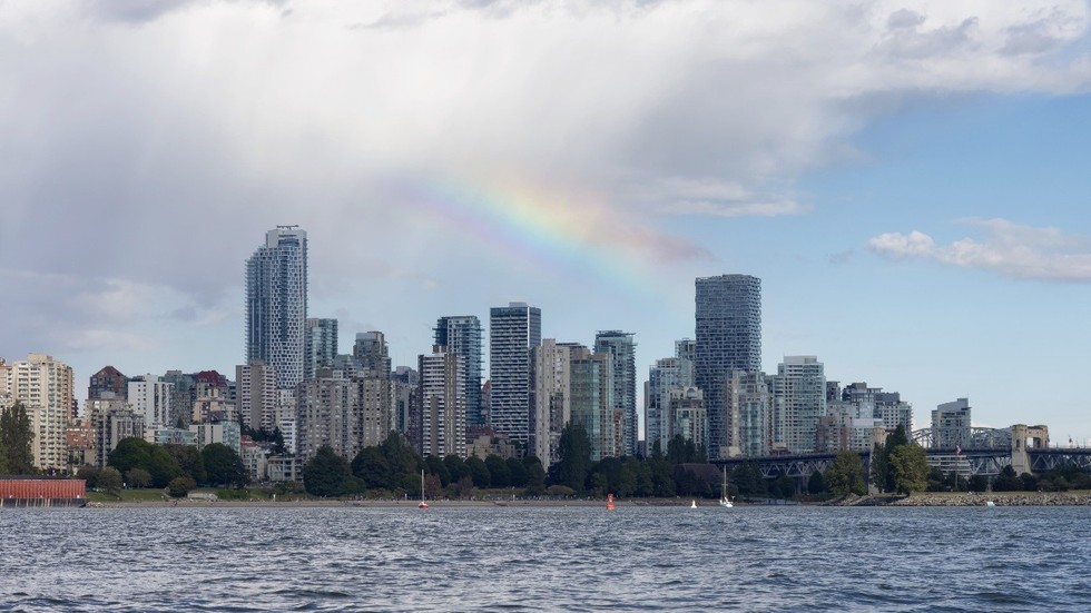 A downtown Vancouver skyline beneath a rainbow.