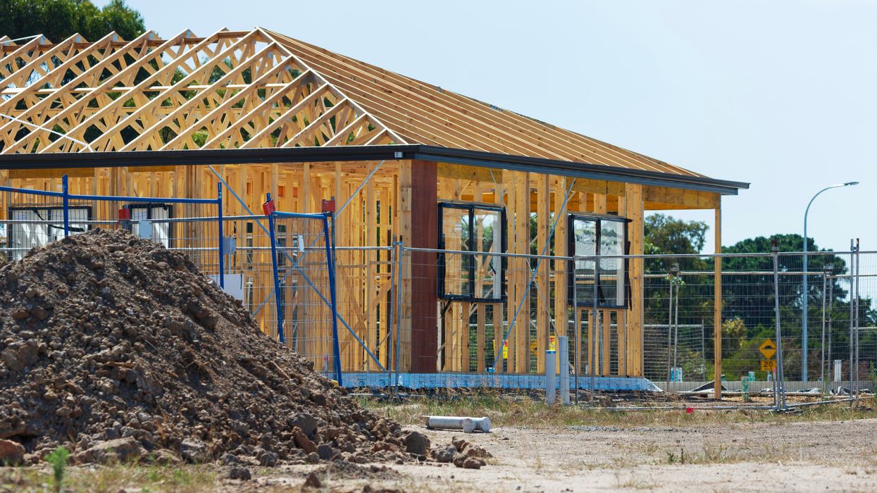 a house under construction with a pile of dirt in front of it