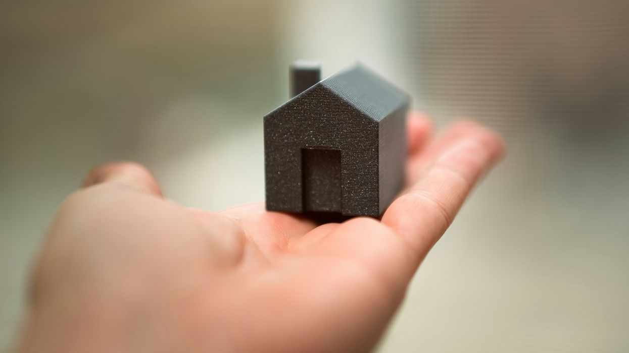 A person holding a small house in their hand