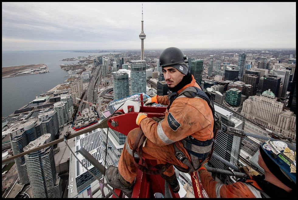 Crane Rigger, Marco Ottorino, sits at the apex of Harbour Plaza\u2019s East Tower Crane as it is taken down in February. The photography for this project took place at the Harbour Plaza and the One York Street site over the past four years.