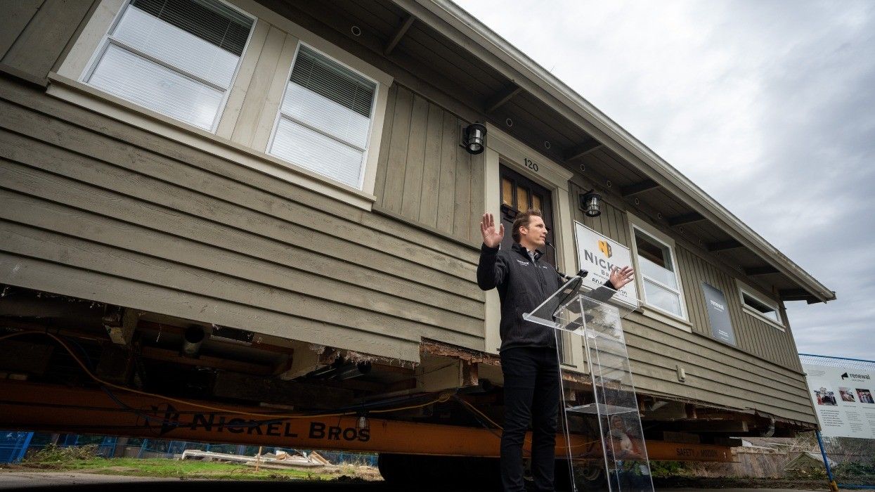 Founder & CEO Glyn Lewis in front of a single-family home set for relocation.