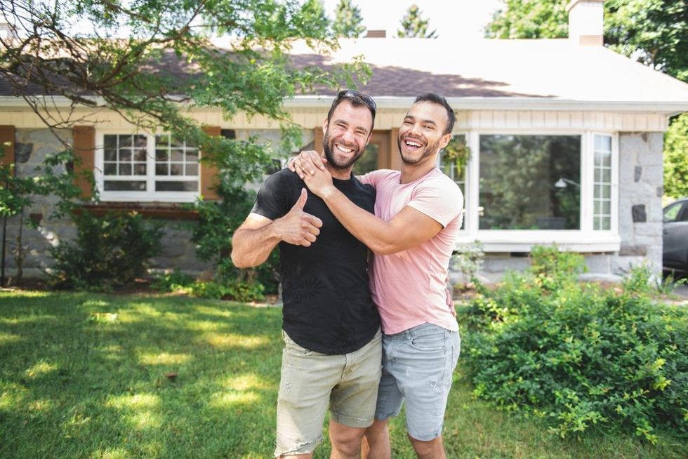 Happy gay couple in front of home 1