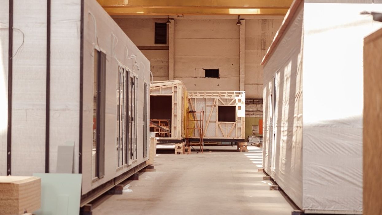 Housing buildings under construction inside a warehouse.