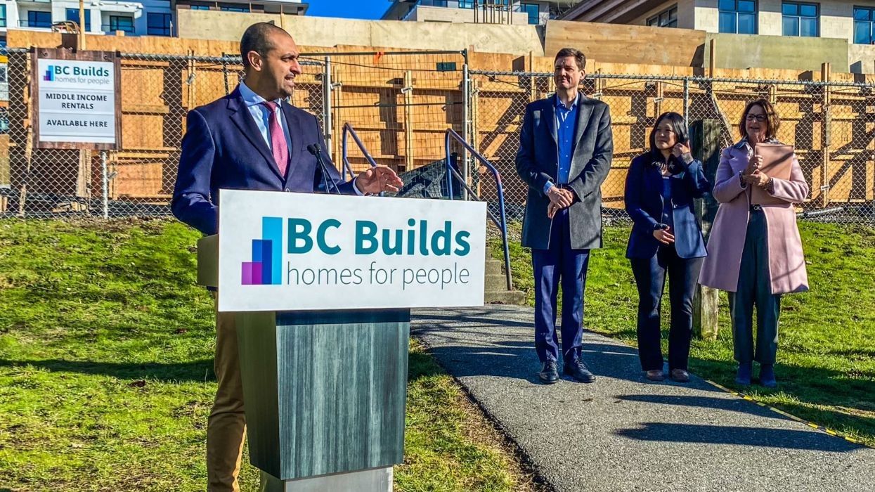 Housing Minister Ravi Kahlon standing at a podium that reads "BC Builds homes for people."