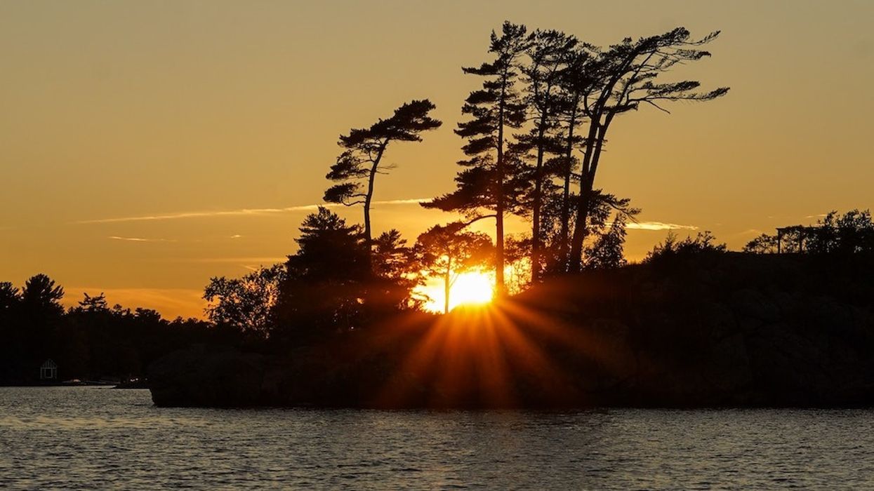Sun setting over a small island in cottage country