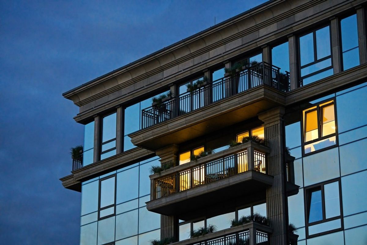 The exterior of a high end apartment building at twilight
