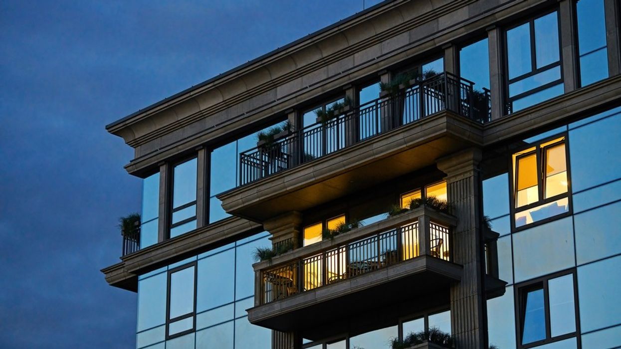 The exterior of a high end apartment building at twilight