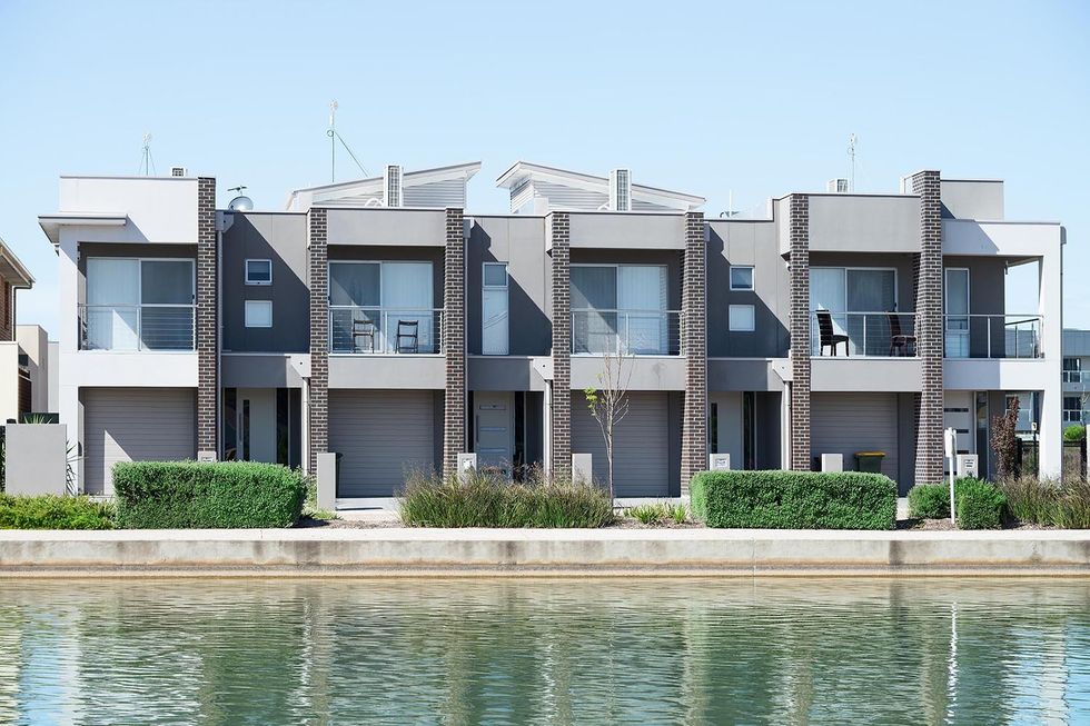 typical facade of a modern town suburban house near the pond at noon